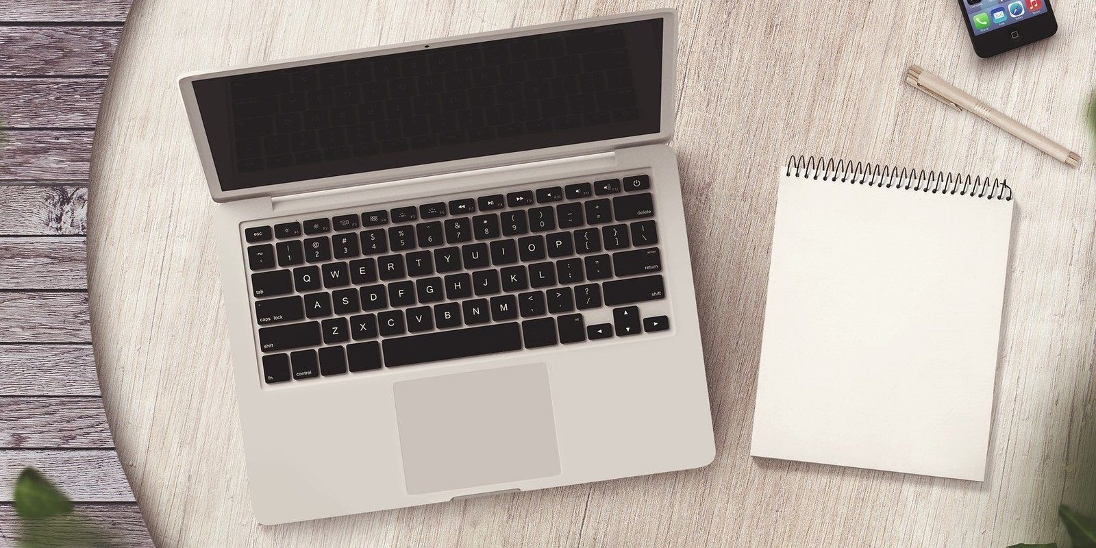 Desarrollador Web Freelance | Wordpress | | a silver laptops with a notepad on a wooden table