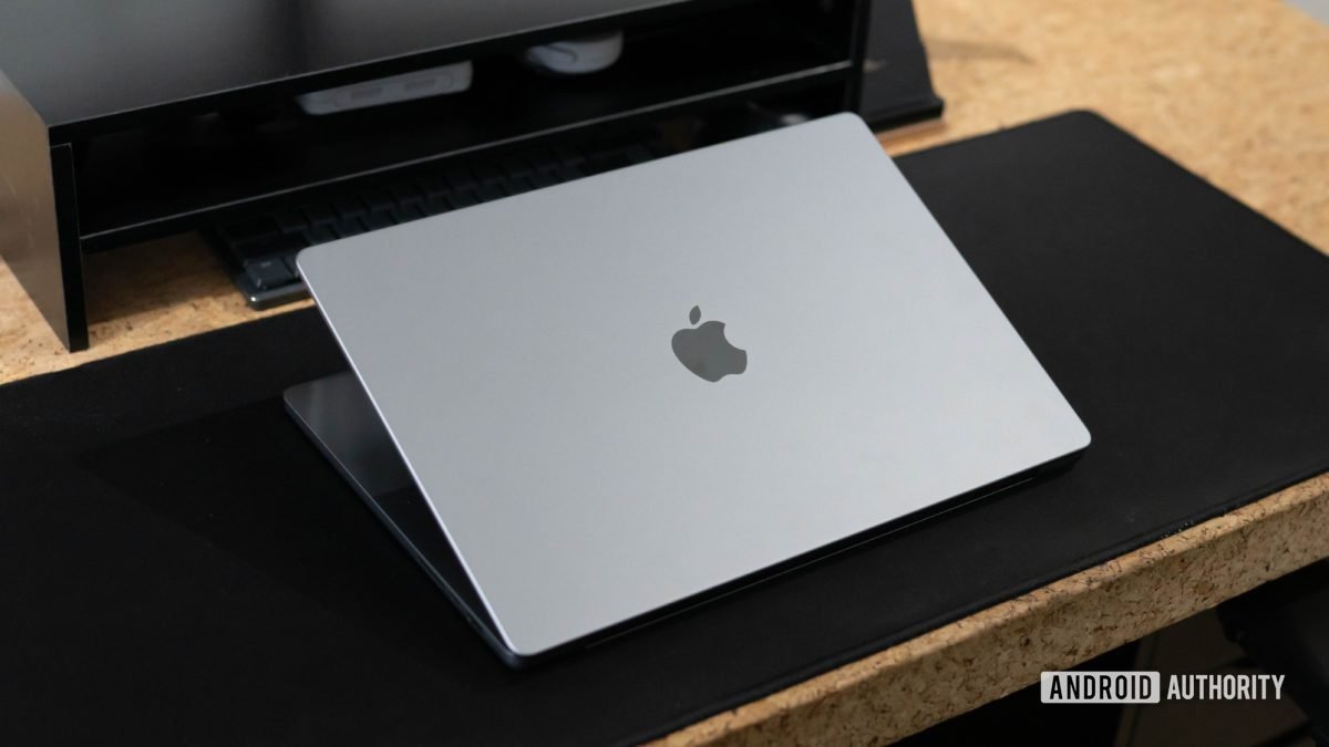 Tapa de Apple MacBook Pro 2023 entreabierta sobre una mesa que muestra el logotipo de Apple Tapa de Apple MacBook Pro 2023 entreabierta sobre una mesa que muestra el logotipo de Apple